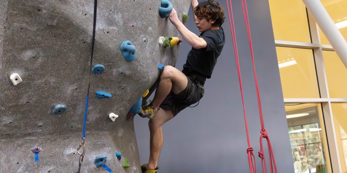 Matthe Menzi carefull places his foot on the hold at the climbing wall